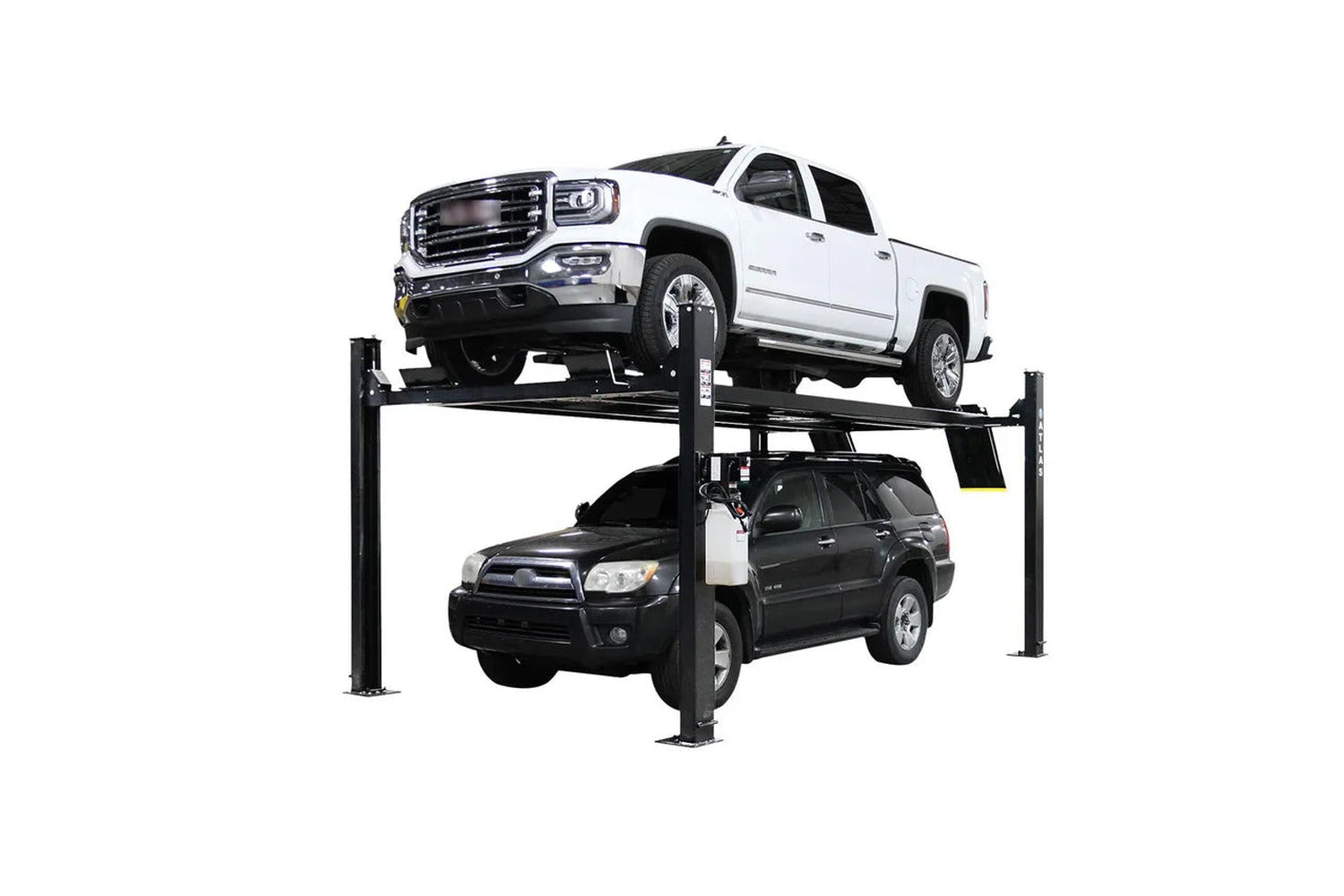 Atlas four-post lift raised with a white GMC Sierra pickup on the runways and a dark SUV parked underneath, showing two-vehicle storage
