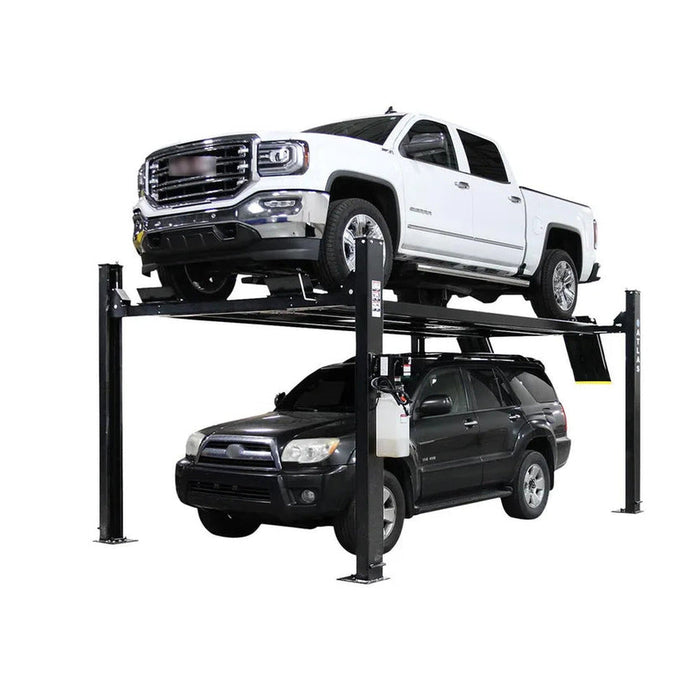 Atlas four-post lift raised with a white GMC Sierra pickup on the runways and a dark SUV parked underneath, showing two-vehicle storage
