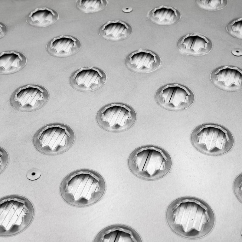 A closeup of the punch plate of the HD Ramps 48" x 36" Punch Plate Shipping Container Ramp