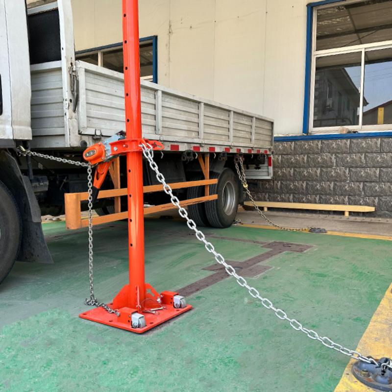 Orange Body Puller with chain in an industrial setting with chain attached to a truck on a green floor.