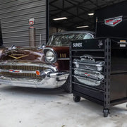 Sunex 8056FDBK57 '57 Chevy cart next to a classic Chevy in a shop