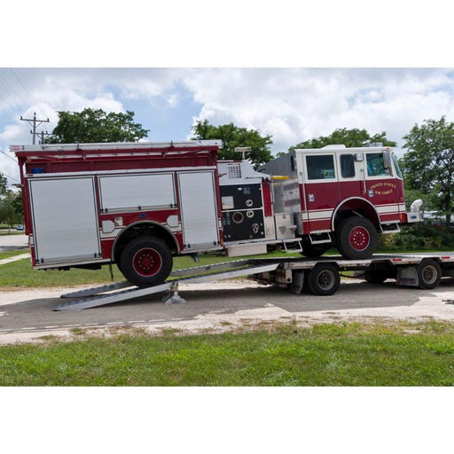 Ramp loading lifts a firetruck onto a step deck trailer using the HD Ramps aluminum bunk ramp kit.
