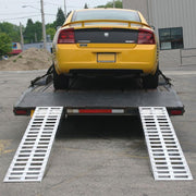 HD Ramps aluminum hook-end car ramps attached to the rear of a trailer shown after loading a vehicle.