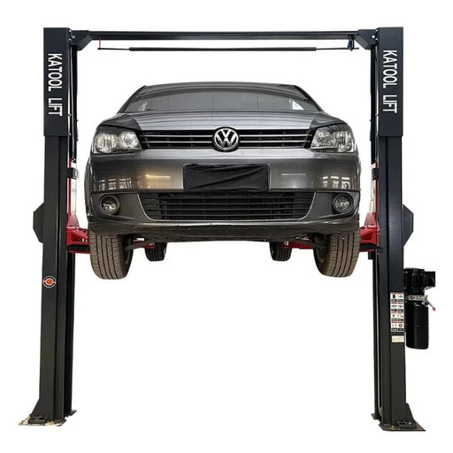 Overhead two-post car lift from KATOOL raising a vehicle with 14,000 lb capacity for professional shop service.