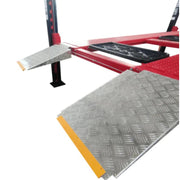 Four post storage lift from Katool showing the diamond-plate ramp for secure vehicle drive-on positioning.