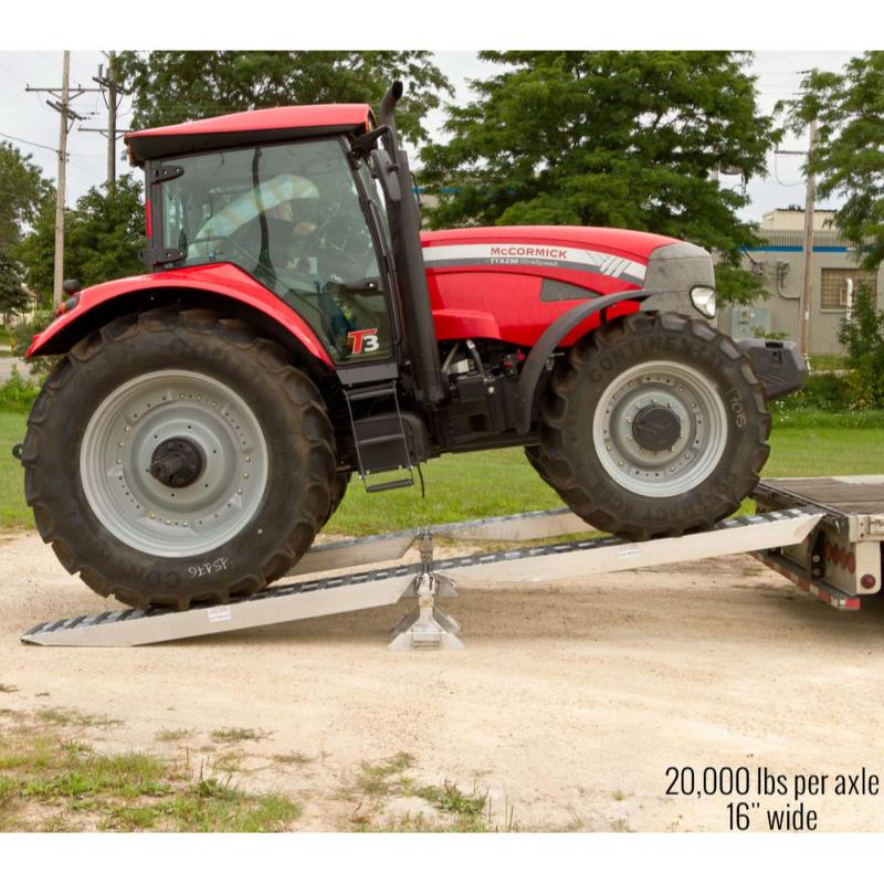 HD Ramps 20,000 lb. modular ramp system is used to safely load a large tractor onto the trailer.